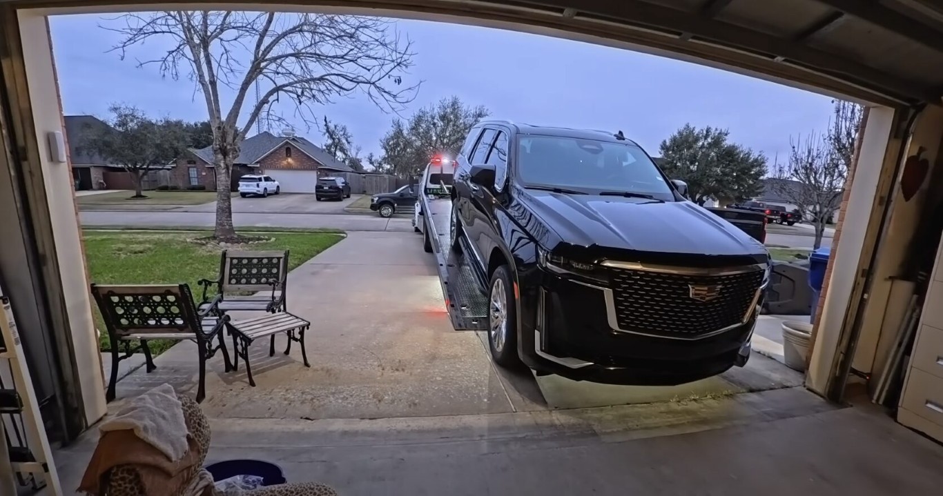 Heavy-duty flatbed towing large SUV in residential area in Gilroy, CA